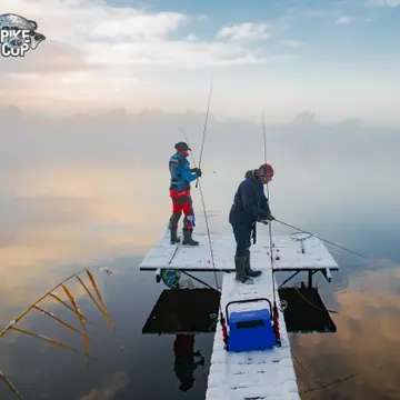 Два рыболова со снастями на понтоне морозным утром