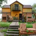 Двухэтажный дом, лестница и скамейки во дворе
